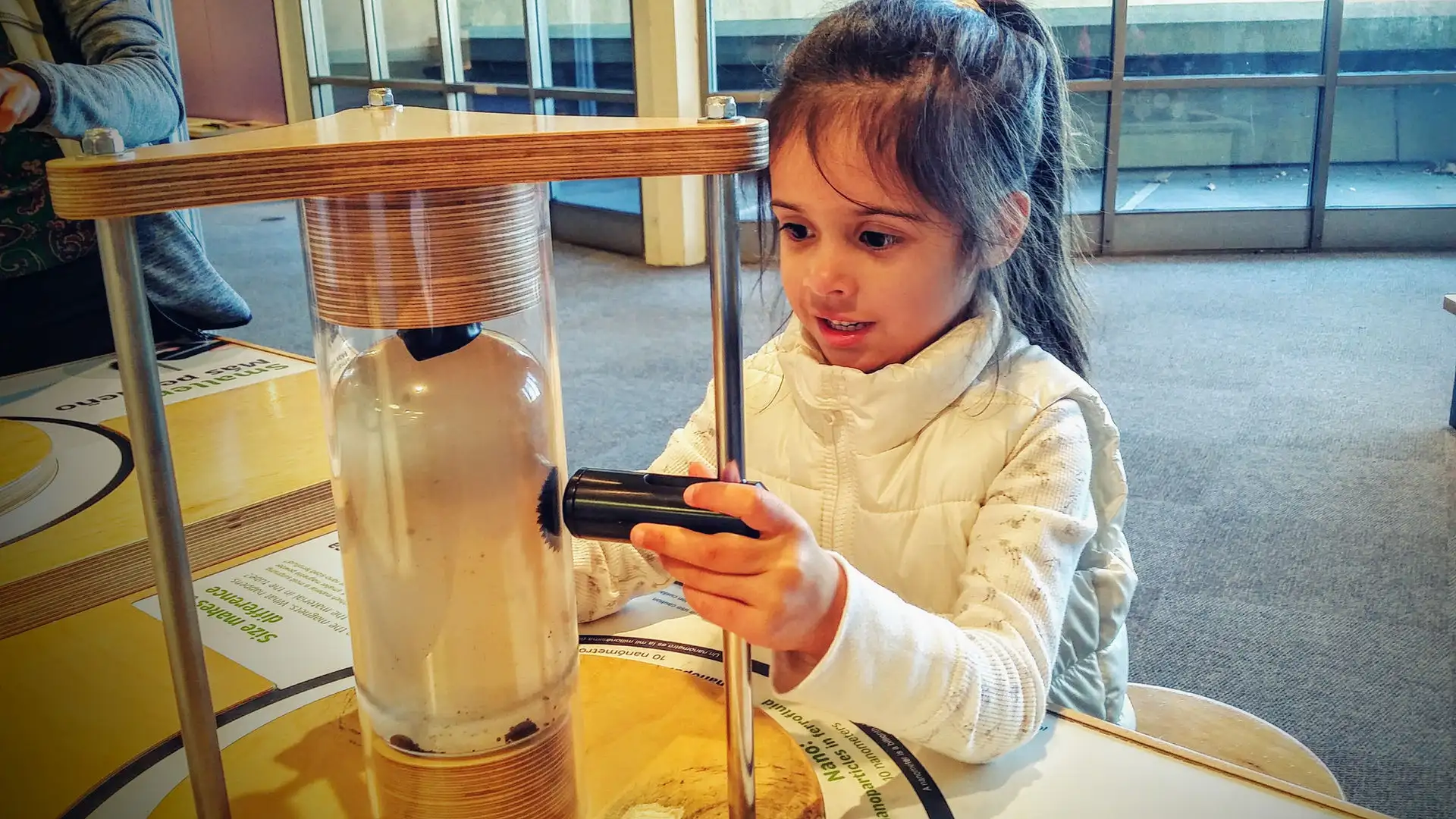 A Pear Tree student examining a science experiment up close