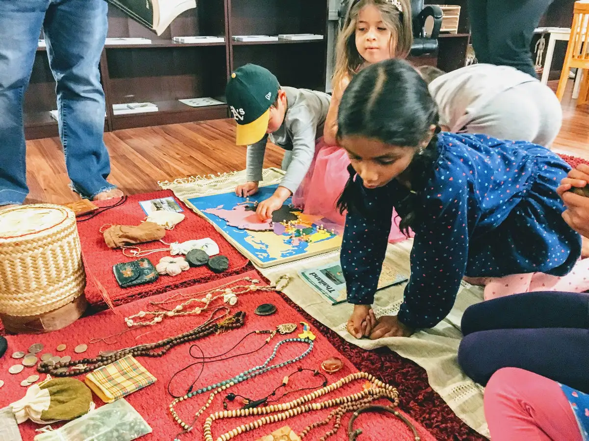Children working on a floor mat in a Montessori classroom